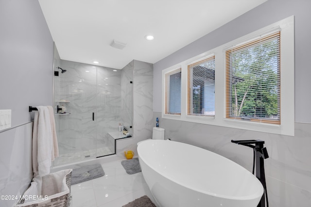 bathroom featuring marble finish floor, recessed lighting, a marble finish shower, tile walls, and a freestanding bath