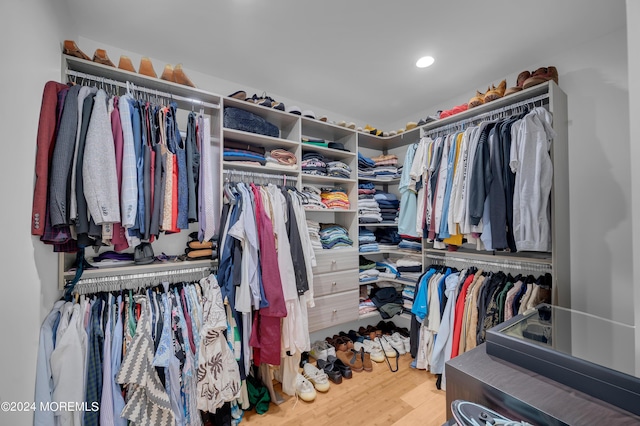 walk in closet with wood finished floors