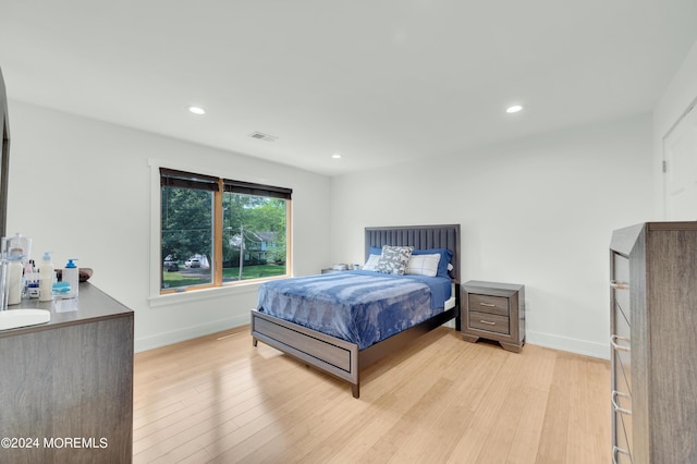 bedroom featuring light wood finished floors, visible vents, recessed lighting, and baseboards