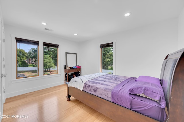 bedroom with recessed lighting, light wood-type flooring, baseboards, and visible vents