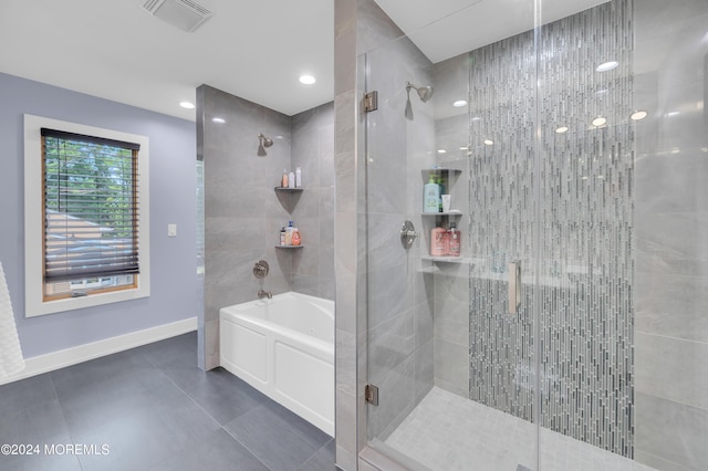 full bathroom with visible vents, a shower stall, a garden tub, and baseboards