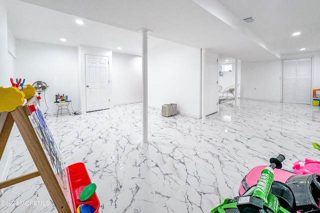 finished basement featuring recessed lighting, visible vents, and marble finish floor