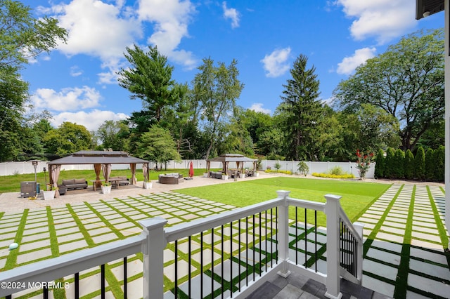 exterior space with an outdoor living space with a fire pit, a gazebo, cooling unit, a fenced backyard, and a patio