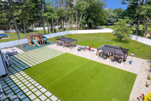 view of community featuring a gazebo, a yard, a playground, and a fenced backyard