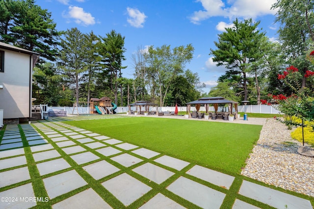 view of yard featuring a gazebo, a patio area, fence, and a playground