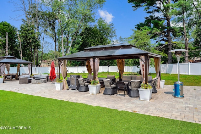 view of patio / terrace featuring a gazebo, an outdoor living space with a fire pit, and a fenced backyard