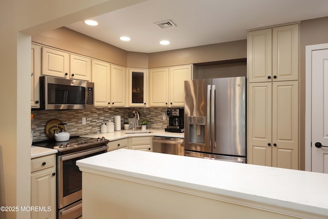 kitchen featuring a sink, decorative backsplash, visible vents, and stainless steel appliances