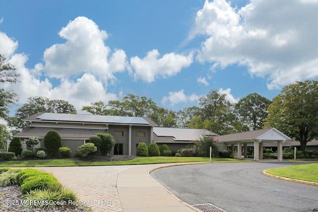 view of front facade featuring curved driveway and a front yard