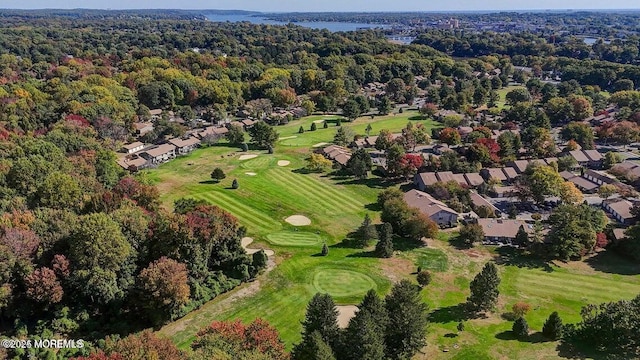 drone / aerial view featuring view of golf course and a wooded view