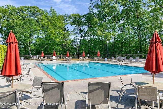 community pool featuring fence and a patio area