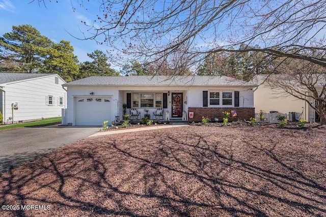 ranch-style home featuring a garage, brick siding, a porch, and driveway