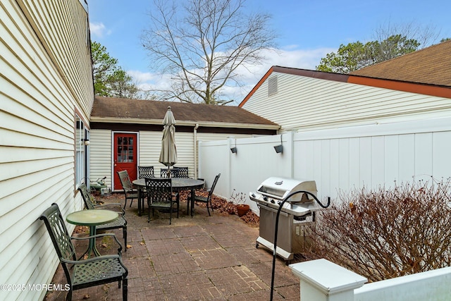 view of patio / terrace featuring area for grilling, outdoor dining space, and fence