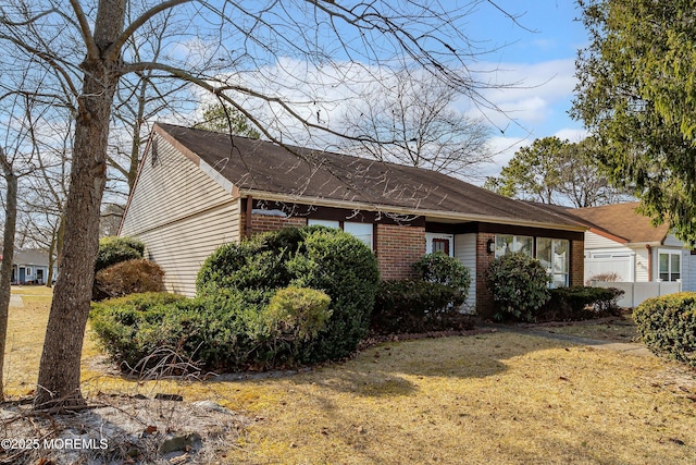 view of front of house featuring brick siding and a front lawn