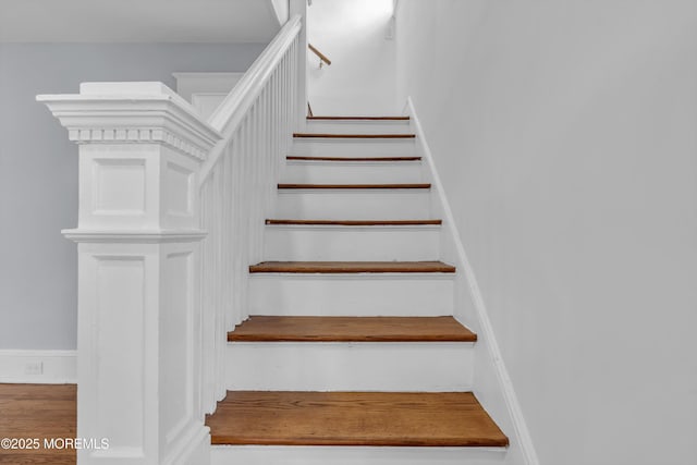 stairs featuring wood finished floors