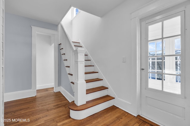 staircase with wood finished floors and baseboards