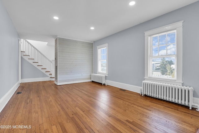 unfurnished room featuring recessed lighting, radiator heating unit, and hardwood / wood-style flooring