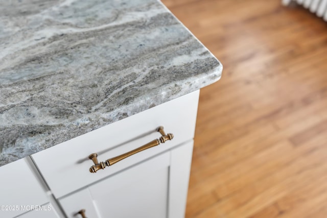 interior details with white cabinets and wood finished floors