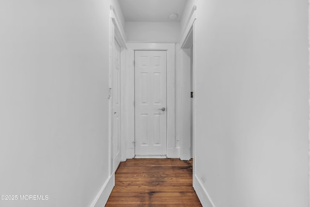 hall featuring dark wood-style floors and baseboards