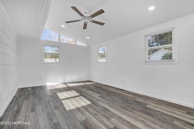 spare room with plenty of natural light, wood finished floors, and vaulted ceiling