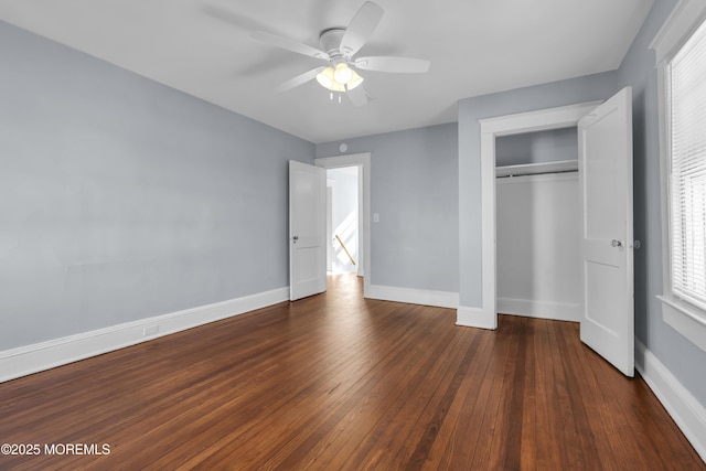 unfurnished bedroom featuring dark wood finished floors, ceiling fan, a closet, and baseboards