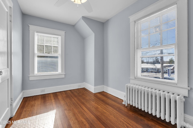 bonus room featuring hardwood / wood-style flooring, radiator heating unit, a ceiling fan, and baseboards