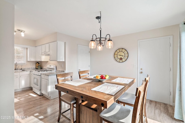 dining space featuring light wood-type flooring and a chandelier