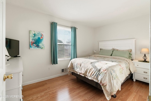 bedroom featuring visible vents, light wood-type flooring, and baseboards