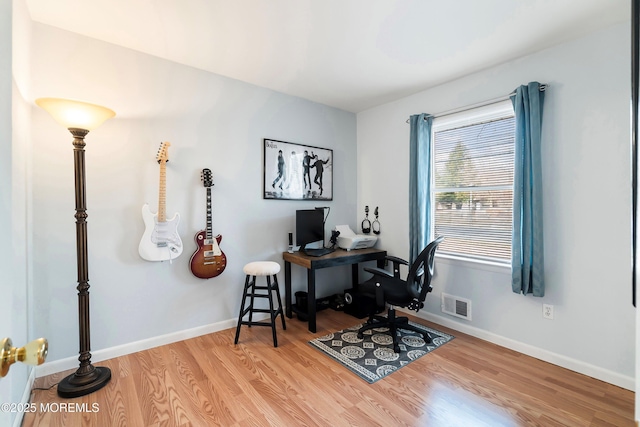 office featuring visible vents, baseboards, and wood finished floors