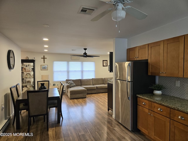 kitchen featuring brown cabinetry, visible vents, freestanding refrigerator, and ceiling fan