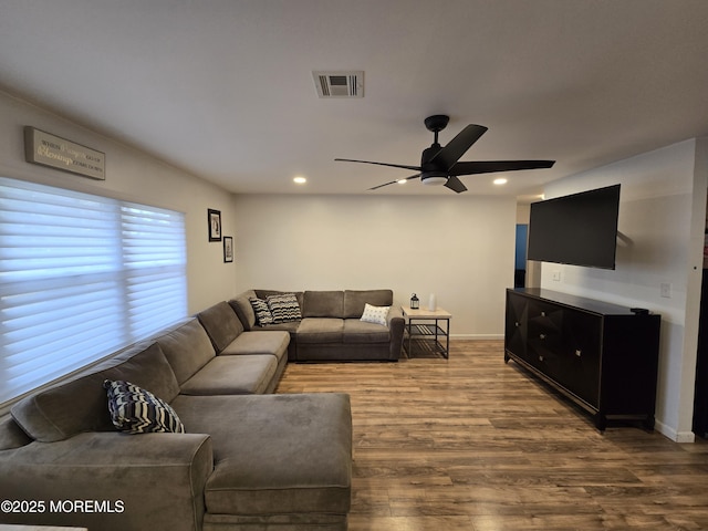 living room with visible vents, baseboards, a ceiling fan, and wood finished floors