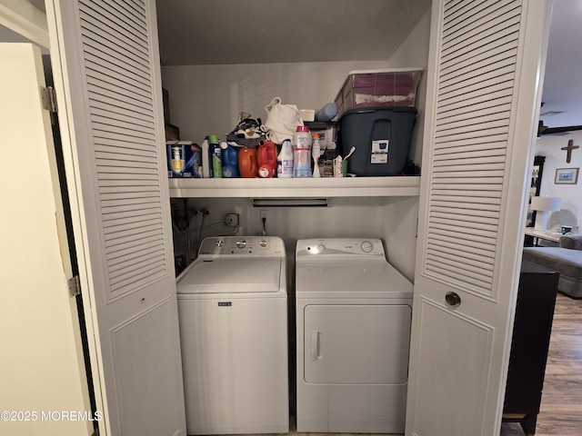 laundry area featuring laundry area, washing machine and dryer, and wood finished floors