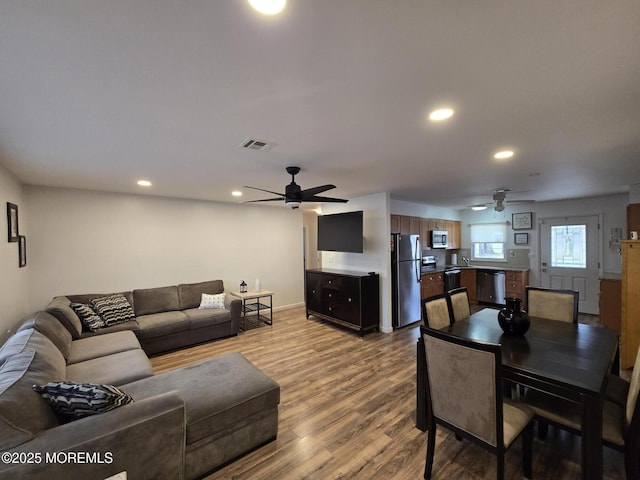 living room featuring visible vents, recessed lighting, a ceiling fan, and wood finished floors