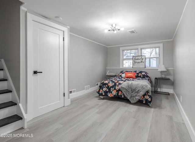 bedroom featuring visible vents, wood finished floors, an inviting chandelier, and ornamental molding