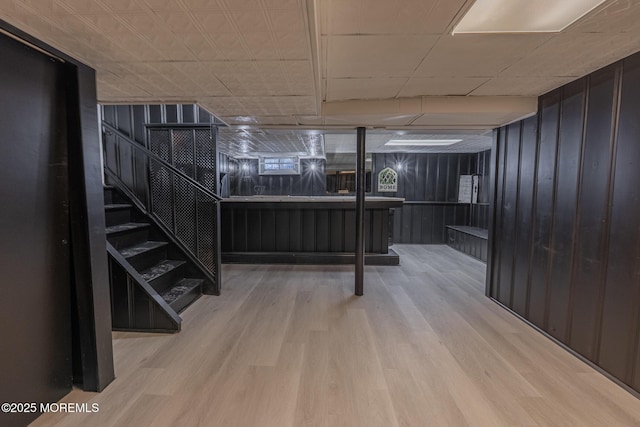 interior space with stairway, wooden walls, and wood finished floors