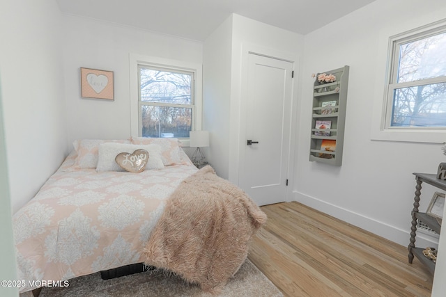 bedroom with light wood-style flooring and baseboards