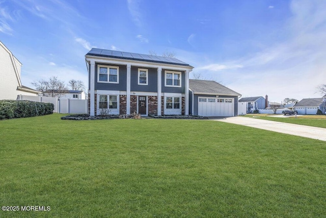 neoclassical home featuring an attached garage, fence, a front yard, roof mounted solar panels, and driveway