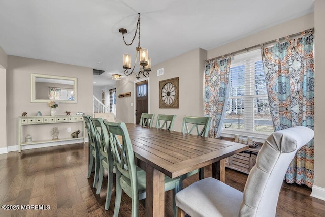 dining room featuring a chandelier, visible vents, baseboards, and wood finished floors