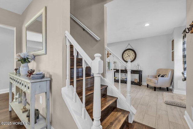 stairway with recessed lighting, wood finished floors, and baseboards