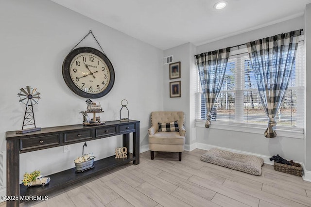 living area featuring visible vents, wood finish floors, and baseboards