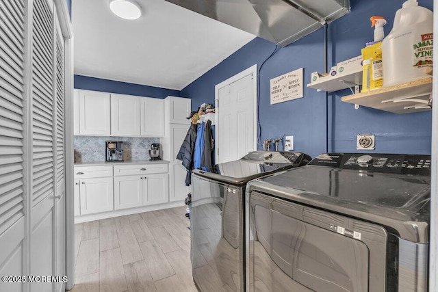 washroom with light wood-type flooring, independent washer and dryer, and laundry area