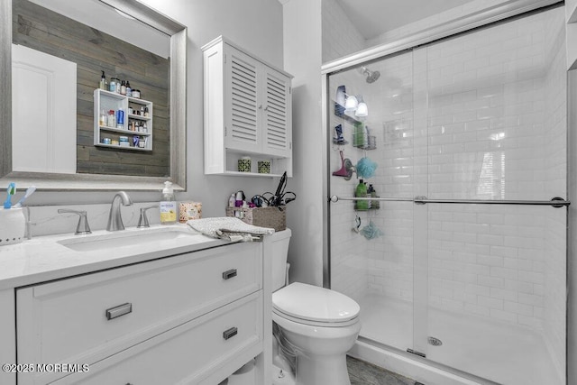 full bath featuring vanity, a shower stall, and toilet