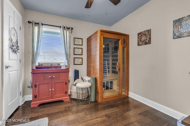 interior space featuring ceiling fan, baseboards, and dark wood finished floors