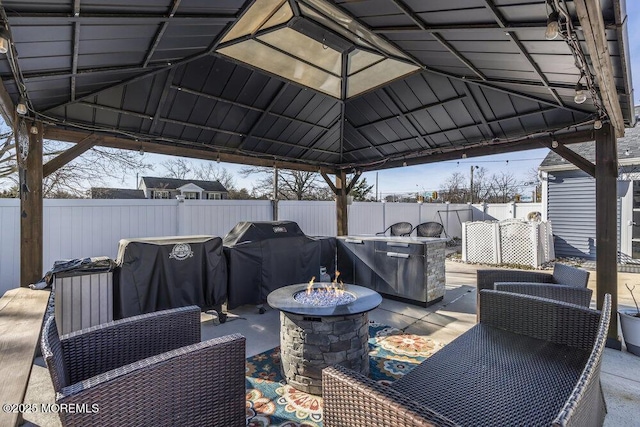 view of patio featuring a gazebo, an outdoor fire pit, a grill, and fence