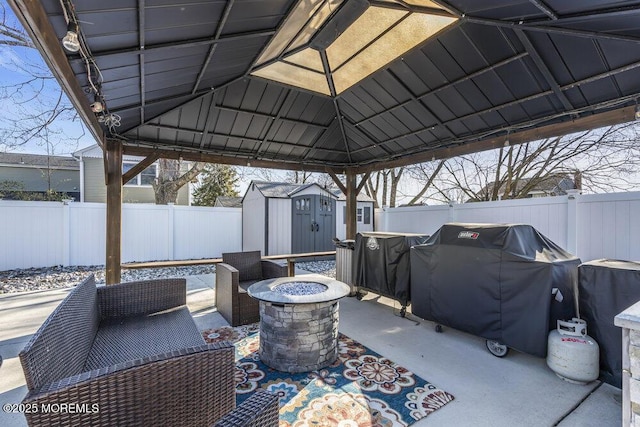 view of patio / terrace featuring an outbuilding, a fenced backyard, an outdoor fire pit, grilling area, and a storage shed