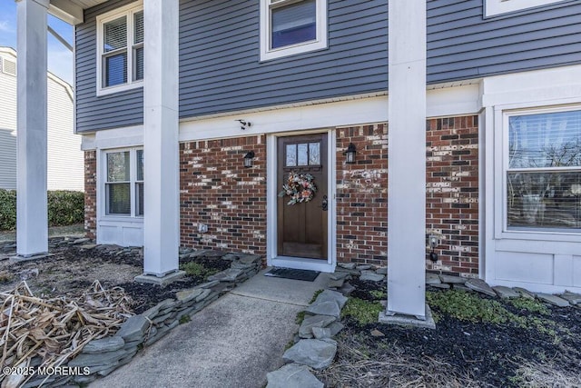 view of exterior entry featuring brick siding