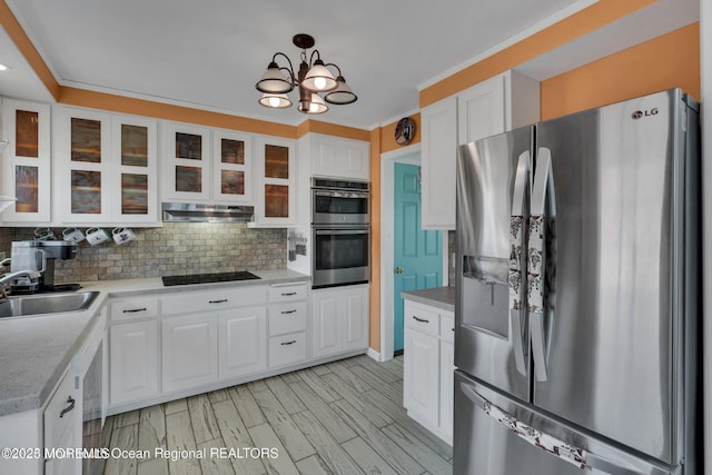 kitchen with white cabinets, decorative backsplash, a sink, and appliances with stainless steel finishes