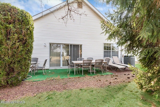 rear view of property featuring a lawn and central AC