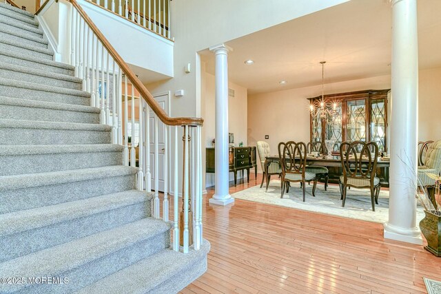 2 Kristen Ct, Franklin Twp, NJ 08873 - staircase with hardwood / wood-style floors, decorative columns, recessed lighting, a towering ceiling, and an inviting chandelier