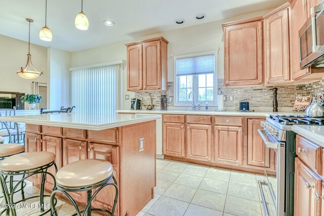 2 Kristen Ct, Franklin Twp, NJ 08873 - kitchen with light brown cabinetry, a center island, stainless steel appliances, a breakfast bar area, and light countertops