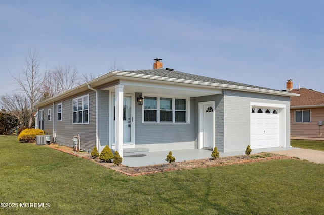 view of front of house featuring a front yard, a chimney, a garage, central air condition unit, and brick siding